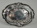 an antique silver plate with a decorative design on the rim