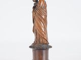 a wooden statue of a woman holding a child on a pedestal