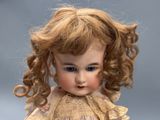 a close up of a doll with blonde hair and blue eyes