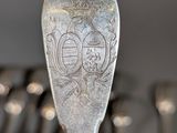 a silver spoon that has a design on it