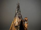 an image of a statue of a person standing next to a teepee