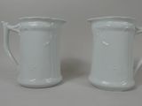 une paire de cruches en porcelaine blanche posées sur une surface blanche