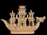 a statue of a dragon on a boat with a building in the background