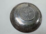 a silver plate with a design on it on a table