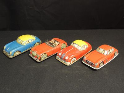 five toy cars are lined up in a row on a black surface