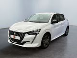 La voiture blanche est garée dans une grande pièce au sol noir.