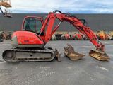 a red excavator that is sitting in a parking lot