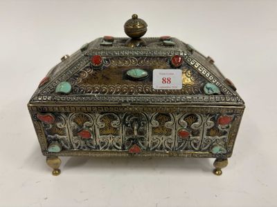 une boîte en argent ornée de motifs rouges et verts