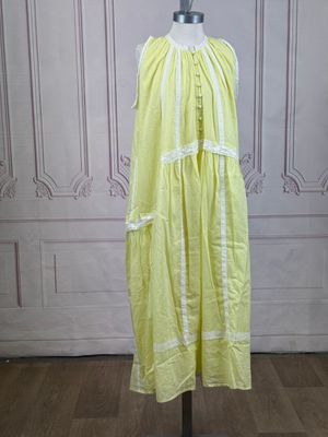 a yellow dress on a mannequin stand on a wooden floor