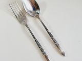 two forks and a spoon sitting on a table