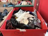 une boîte rouge remplie de nombreux vêtements et chaussures