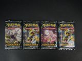 trois paquets de cartes à collectionner Pokémon posés sur une table