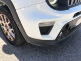 the front end of a white jeep parked in a parking lot