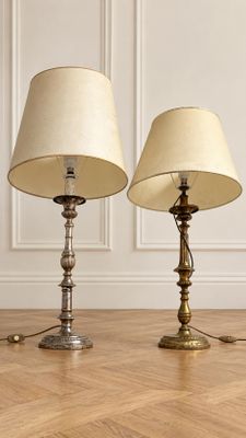 three lamps on a wooden floor in a room with a white wall