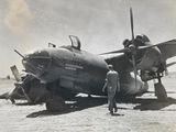 a man standing next to an old airplane in a field
