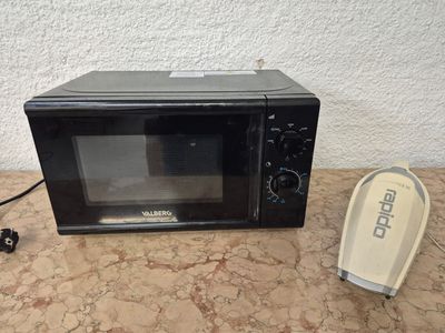un micro-ondes posé sur une table à côté d'un téléphone