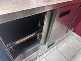 stainless steel counter top with open oven door in a commercial kitchen