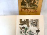 un livre ouvert posé sur une table blanche, à côté d'un livre sur lequel figure la photo d'une personne