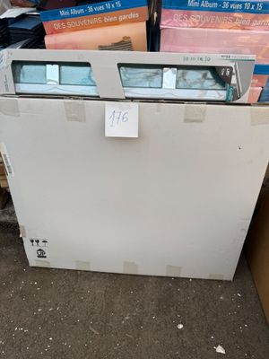 un congélateur coffre blanc posé devant une pile de cartons