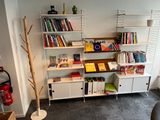 a book shelf in the corner of a room with books on it