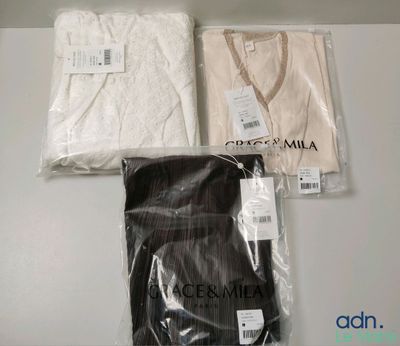 Il y a deux chemises blanches et une chemise noire sur une table