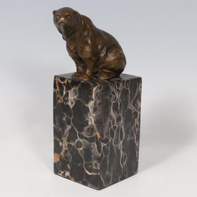 statue d'un ours assis sur un bloc de marbre, sur fond blanc