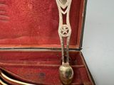 a silver spoon in a red case with a gold spoon in it
