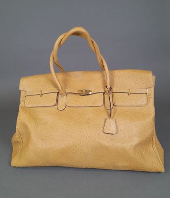 a tan leather handbag on a grey background