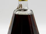 a bottle of syrup sitting on a white surface