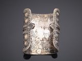 a close up of a silver bracelet on a black background