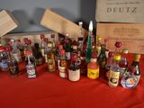 many bottles of alcohol on a table with a red table cloth