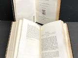 an open book sitting on top of a table next to a metal holder