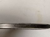 a close up of a metal spoon with a handle on a white surface