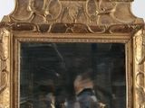 un miroir avec un cadre doré et un homme qui se prend en photo dedans
