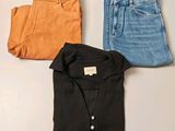 three pairs of jeans and a shirt on a table
