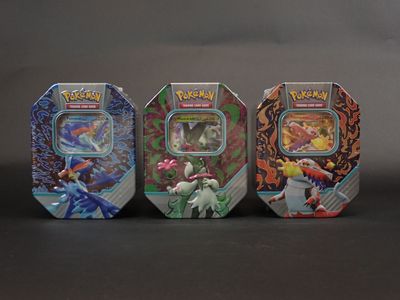 Quatre types différents de boîtes Pokémon sont alignées les unes à côté des autres.