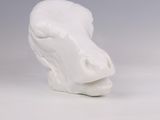 un gros plan sur une sculpture en céramique blanche représentant une vache