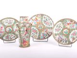 four pieces of chinese vases and plates on stands on a white surface