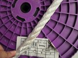 someone is holding a purple spool with a white rope around it