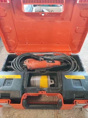 une boîte à outils orange contenant une perceuse et un câble