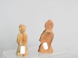 two figurines sitting on a clear display case