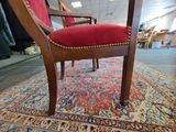 a red chair that is on a rug in a room