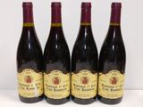 quatre bouteilles de vin sont alignées sur une table