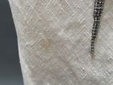 a close up of a white dress with a black and white beaded belt