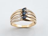 une photo d'une bague en or sertie de saphirs bleus et de diamants