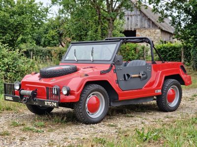 une jeep rouge garée dans l'herbe