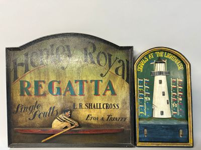 two plaques on the wall with a lighthouse in the background