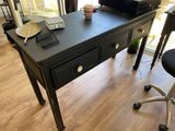 a black desk with a computer on top of it