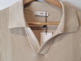 a close up of a sweater hanging on a hanger on a wall