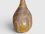 a brown vase with a design on it on a white surface